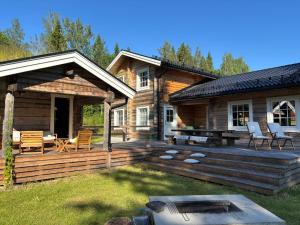a log cabin with a deck and a patio at The Moose Lodge Swedish Nature Retreat in Bräcke