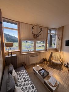 a living room with a couch and a table at Studio duplex hyper centre 4 personnes in Le Lioran