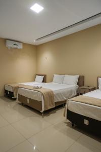 una stanza con due letti in una stanza di Pousada BarbacoaR a Parnaíba