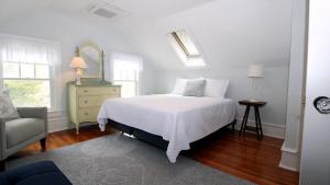 una camera da letto con un letto, una sedia e uno specchio di Cape May Classic a Cape May