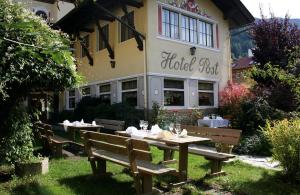 tavolo e panche di fronte a un edificio di Hotel Post a Grosskirchheim