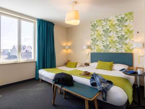 une chambre d'hôtel avec deux lits et une fenêtre dans l'établissement ibis Styles Calais Centre, à Calais 79 autres photos
