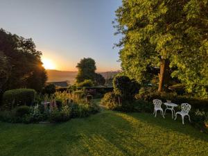 a garden with two chairs and a table in the grass at King's Hill Guest House in Hilton