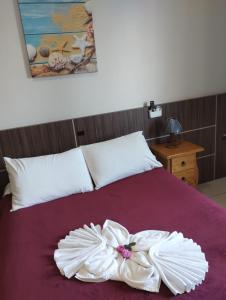 a bed with a white dress on top of it at Miotto Executive Hotel in Navegantes