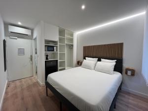 a bedroom with a large bed with white sheets at Studio Hôtel-Restaurant LTB La Table Basque in Biarritz