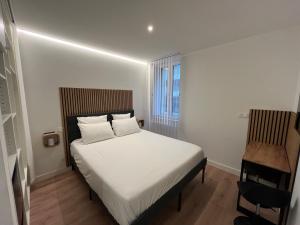 a bedroom with a white bed and a chair at Studio Hôtel-Restaurant LTB La Table Basque in Biarritz +21 photos