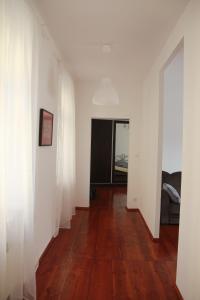 um corredor vazio com paredes brancas e pisos de madeira em M&M Centrum Apartments em Poznań