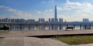 a person sitting on a bench looking at the city at Maison de Jann in Seoul
