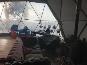 een woonkamer met een bank in een tent bij Kurandero Temple in Bensafrim +4 foto's