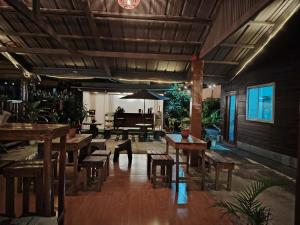 een restaurant met houten tafels en banken en een piano bij La Casa Josefina in Aga