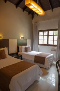 een hotelkamer met twee bedden en een raam bij Portezuelo Hotel in Salta
