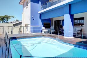 a swimming pool in front of a house at Ahoy Boutique Hotel in Gqeberha