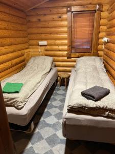 een slaapkamer met 2 bedden in een houten hut bij Øse Camping in Gratangen