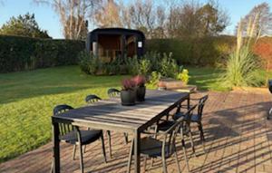 een houten tafel en stoelen op een terras bij Amazing Home In Odder With Sauna in Odder +15 foto's