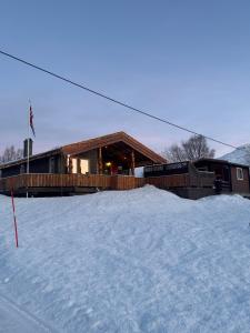 een huis in de sneeuw met een berg sneeuw bij Øse Camping in Gratangen