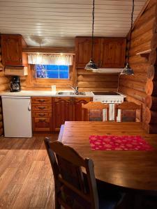 een keuken met een houten tafel in een huisje bij Øse Camping in Gratangen