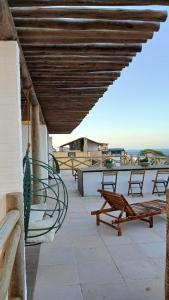 a patio with benches and tables on a building at Pousada Solarium in Canoa Quebrada