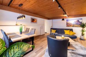 een eetkamer met een tafel en een bank bij Ferienwohnung Hans - Hohenpeißenberg mit Gartenblick in Hohenpeißenberg