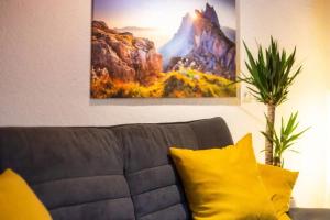 een bank met gele kussens in de woonkamer bij Ferienwohnung Hans - Hohenpeißenberg mit Gartenblick in Hohenpeißenberg