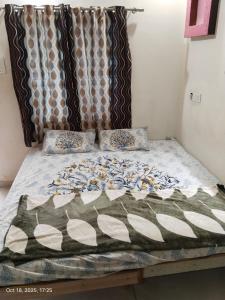 un letto con piumone e cuscini sopra di Bapa Sitaram Homestay a Garudeshwar