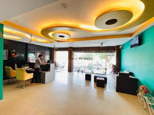 a man standing at a counter in a room at Hotel Soho Corporate 62 in Ghaziabad
