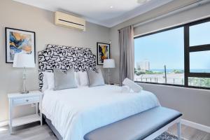 a bedroom with a bed and a large window at Ahoy Boutique Hotel in Gqeberha +39 photos