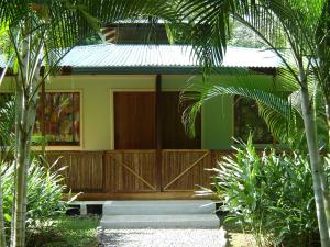 Casa con puerta de madera y porche en El Colibri Lodge en Puerto Manzanillo
