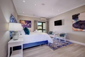 a bedroom with a bed and a table and chairs at Ahoy Boutique Hotel in Gqeberha
