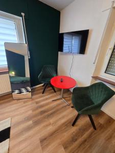 une chambre avec deux chaises et une table rouge dans l'établissement GreenHell Stays, à Adenau 6 autres photos
