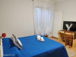 a bedroom with a blue bed with two towels at La Villa Di Zio Pino in Camerino