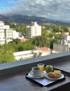 ein Teller Essen mit einer Tasse Kaffee und einem Apfel in der Unterkunft Hotel Internacional in Mendoza