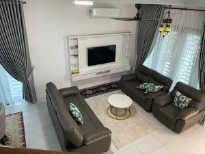 a living room with two couches and a television at Mars Homestay in Alor Setar