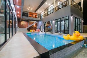 a pool in a house with yellow rubber ducks in the middle at บ้านบรรยากาศ พูลวิลล่าชะอำ in Ban Bo Prakhon
