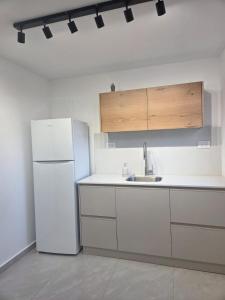 a kitchen with a white refrigerator and a sink at Atalya Suite in Eilat