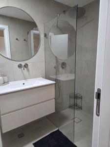 a bathroom with a shower and a sink and a mirror at Atalya Suite in Eilat