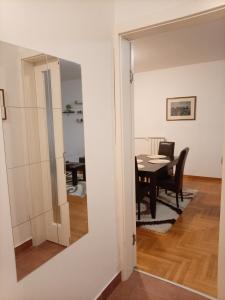 eine Tür, die in ein Esszimmer mit einem Tisch führt in der Unterkunft Linda Apartments- Arena in Novi Beograd