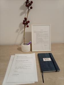 ein Tisch mit einem Buch und einer Vase mit einer Pflanze in der Unterkunft Linda Apartments- Arena in Novi Beograd