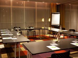a room with tables and chairs and a projection screen at ibis Styles Antibes in Antibes