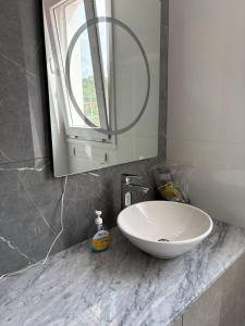 een badkamer met een witte wastafel en een spiegel bij Departamento Cómodo in Tarija +15 foto's