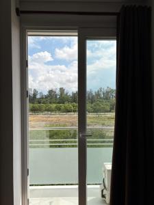een glazen schuifdeur met uitzicht op een veld bij Departamento Cómodo in Tarija