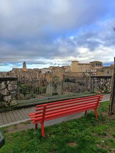 een rode bank die voor een stad staat bij The secret room in Pitigliano