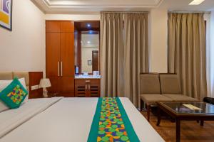 ein Hotelzimmer mit einem Bett und einem Stuhl in der Unterkunft Treebo Royal Star in Neu-Delhi + 37 Fotos