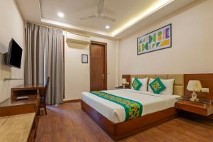 ein Schlafzimmer mit Bett, Schreibtisch und Fernseher in der Unterkunft Treebo Royal Star in Neu-Delhi