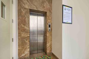 einen Aufzug mit Glastür in einem Gebäude in der Unterkunft Treebo Royal Star in Neu-Delhi