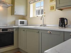 een keuken met een spoelbak en een magnetron bij The Stables in Whissendine