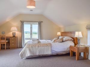 een slaapkamer met een groot bed en een raam bij The Stables in Whissendine +8 foto's