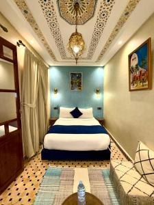 une chambre avec un grand lit avec un mur bleu dans l'établissement Riad Touhfa Kasbah Marrakech, à Marrakech