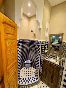 une salle de bain avec une douche carrelée bleue et blanche dans l'établissement Riad Touhfa Kasbah Marrakech, à Marrakech