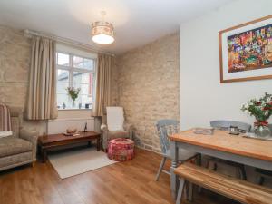 a living room with a table and a chair at Waterloo Mill Cottage in Wotton under Edge