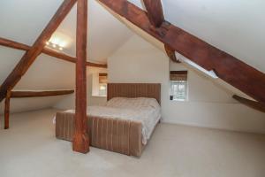 a bedroom with a bed in a attic at Waterloo Mill Cottage in Wotton under Edge